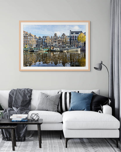 Casas tradicionales de Ámsterdam frente al canal con barcos amarrados y reflejos en el agua