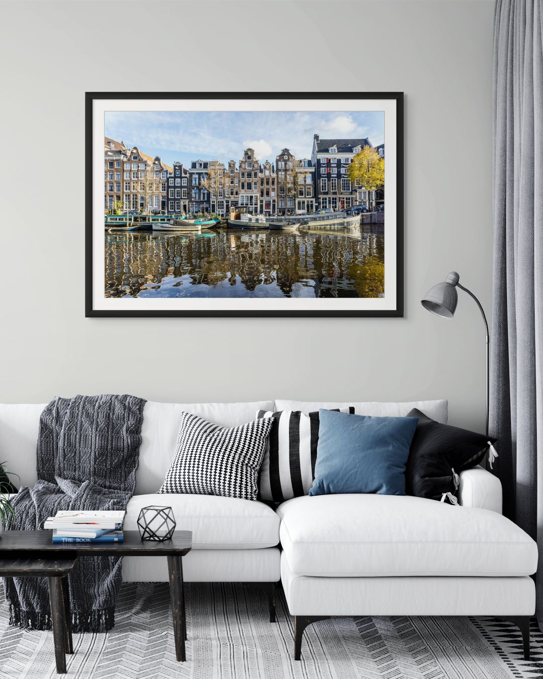 Casas tradicionales de Ámsterdam frente al canal con barcos amarrados y reflejos en el agua