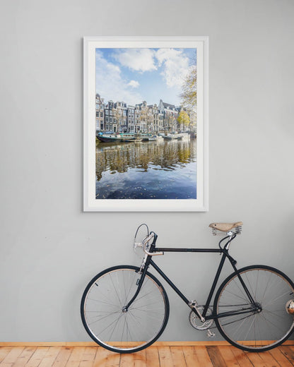 Canal de Ámsterdam en otoño con casas tradicionales, barcas y reflejos sobre el agua.
